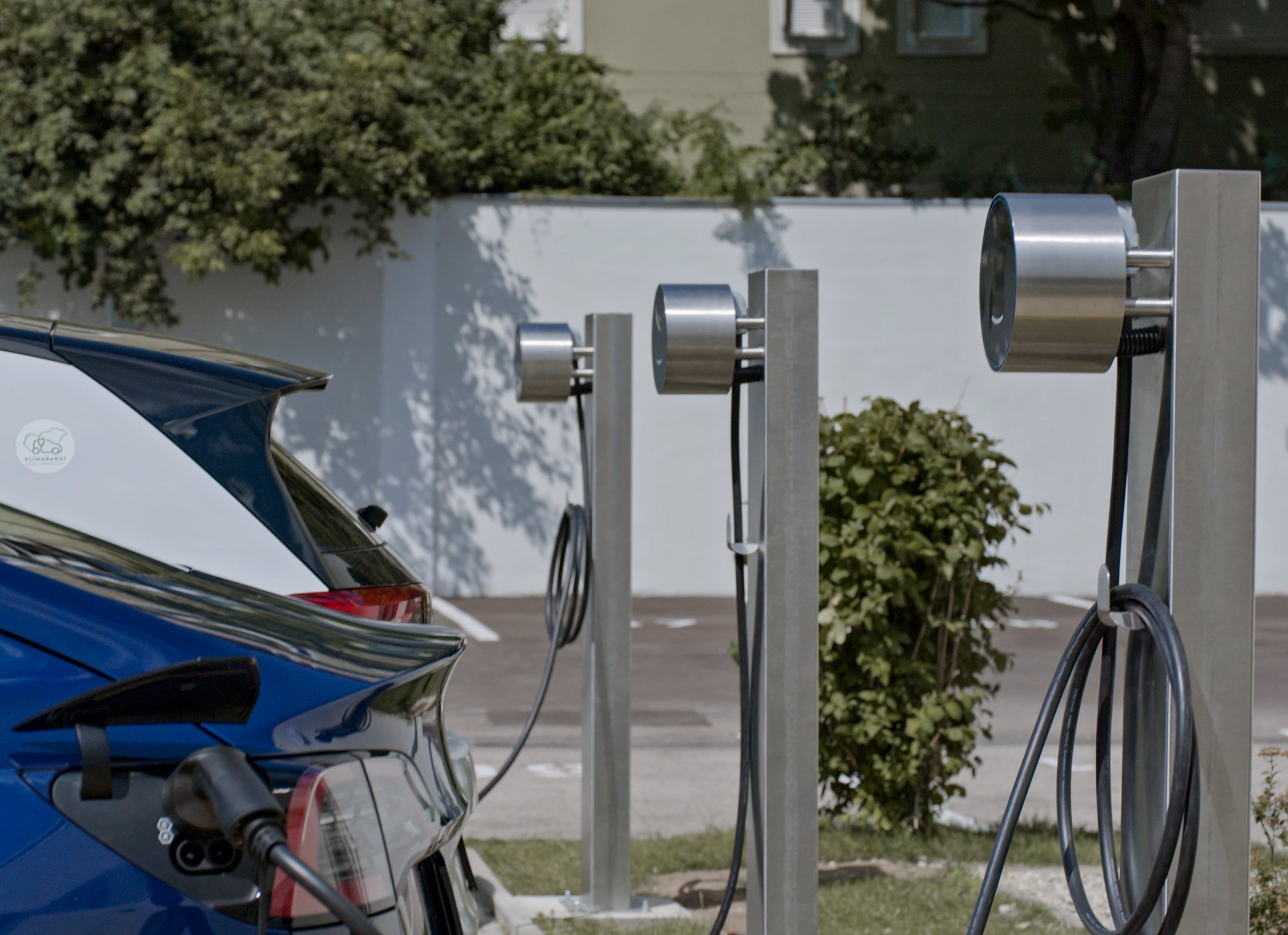 Voltie pedestal chargers beside an electric car in a parking space