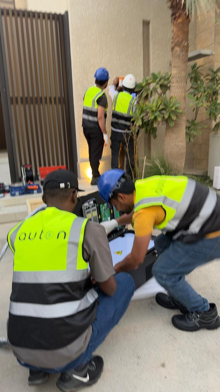 Auton installers in hard hats fitting a charger