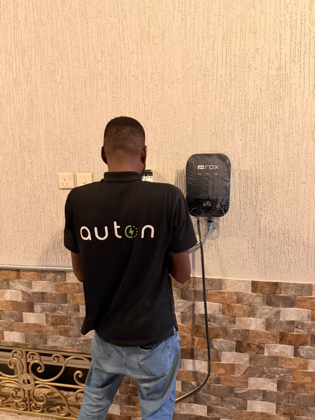 An Auton installer fitting a wall charger