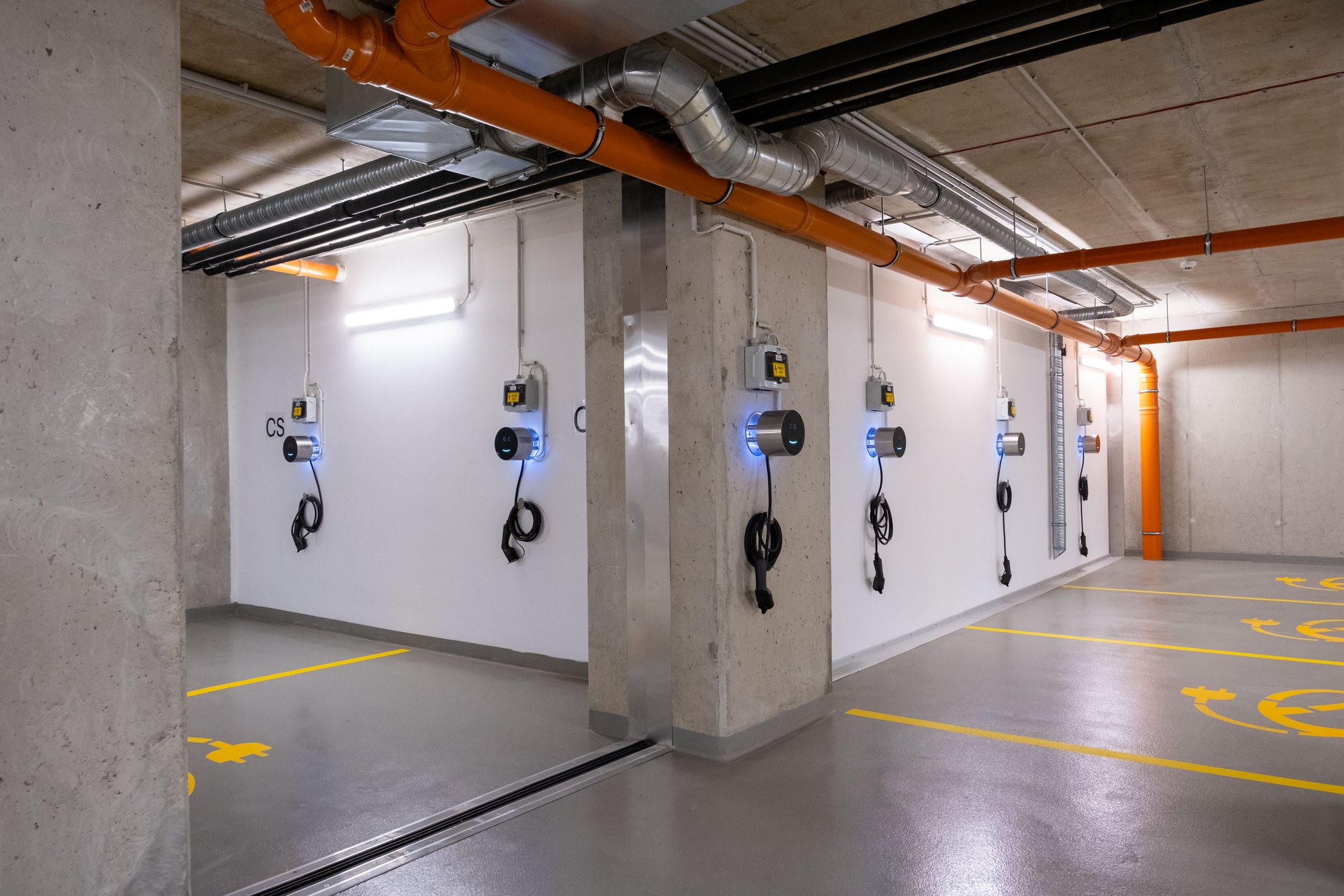A row of Voltie chargers along a car park wall